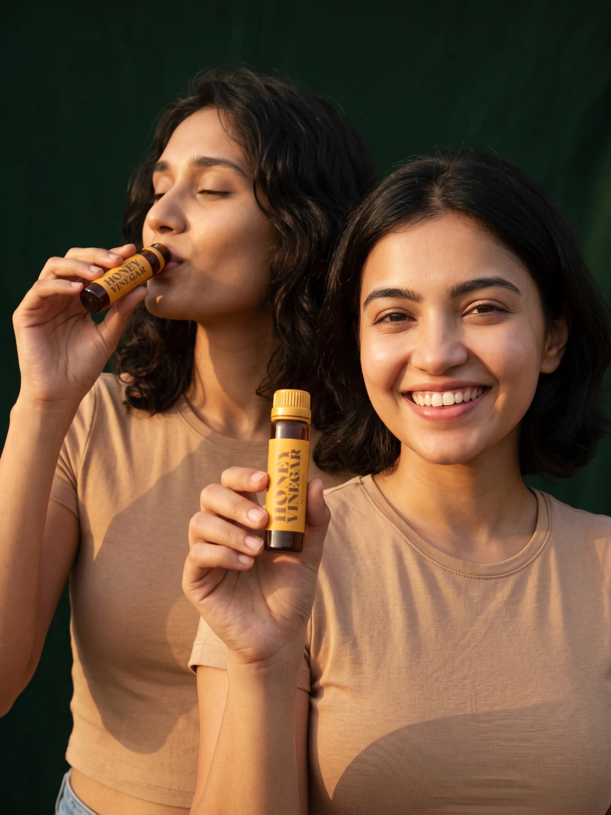 Two women together, one drinking Honey Vinegar and one smiling while holding a bottle